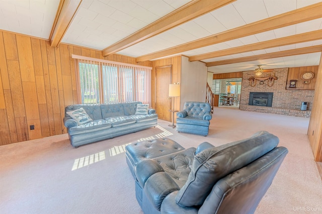 536 N W Gulliver Lake Rd, Gulliver, MI 49840 - living room featuring wooden walls, carpet flooring, beam ceiling, a brick fireplace, and ceiling fan