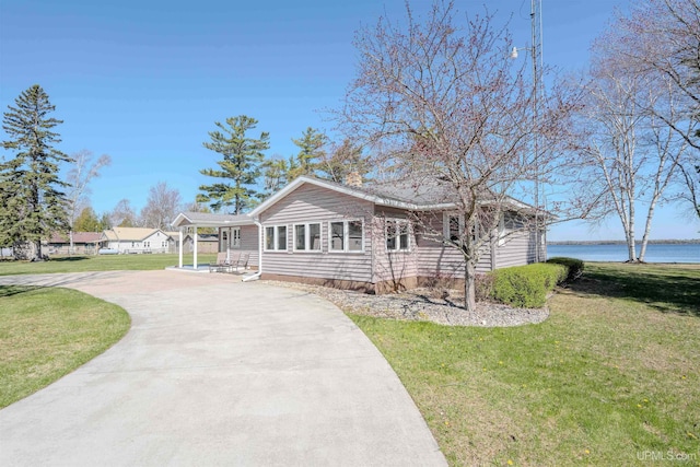 536 N W Gulliver Lake Rd, Gulliver, MI 49840 - view of front facade featuring concrete driveway, a front yard, and a water view