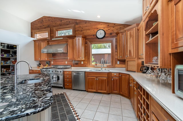 kitchen featuring stainless steel appliances, wall chimney range hood, a sink, vaulted ceiling, and light tile patterned floors