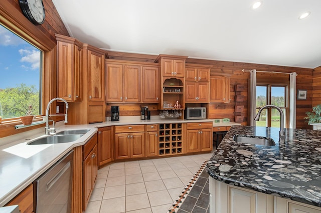 kitchen with a sink, appliances with stainless steel finishes, light tile patterned floors, brown cabinets, and recessed lighting