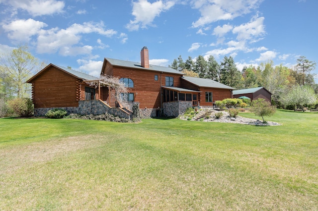 back of property featuring a chimney and a yard