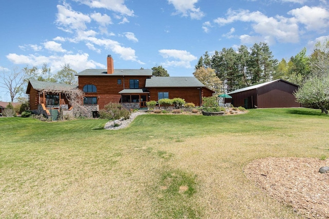 rear view of property with a lawn and a chimney