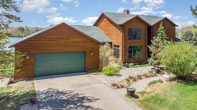 log cabin featuring log exterior, a chimney, a garage, concrete driveway, and roof with shingles