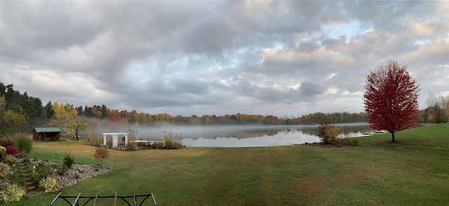 view of green lawn with a water view