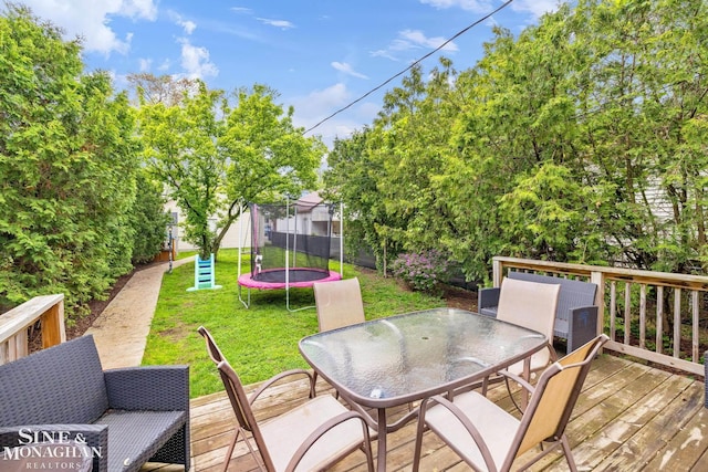 1117 Lakepointe St, Grosse Pointe Park, MI 48230 - deck with a trampoline, outdoor dining space, and a lawn