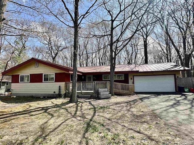 39 Stonegate Hts, Marquette, MI 49855 - ranch-style house featuring an attached garage, asphalt driveway, covered porch, and metal roof