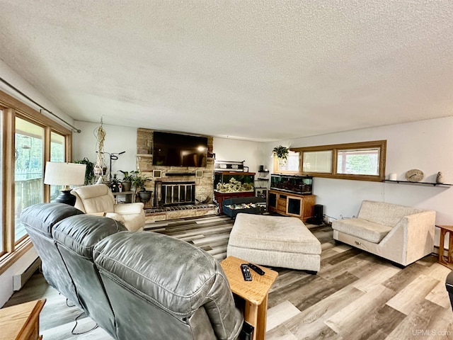 39 Stonegate Hts, Marquette, MI 49855 - living room with healthy amount of natural light, a textured ceiling, wood finished floors, and a stone fireplace