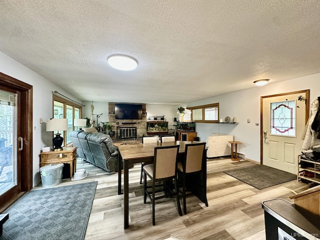 39 Stonegate Hts, Marquette, MI 49855 - dining area featuring a fireplace, a textured ceiling, and light wood-style flooring