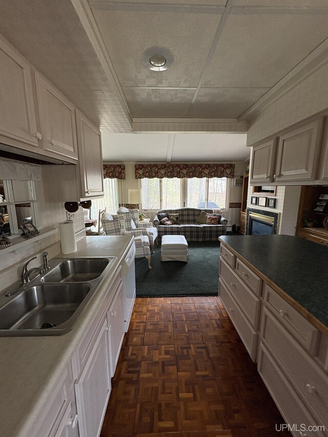 303 Jonathon Carver Rd, Marquette, MI 49855 - kitchen with a sink, white dishwasher, oven, a tray ceiling, and white cabinetry