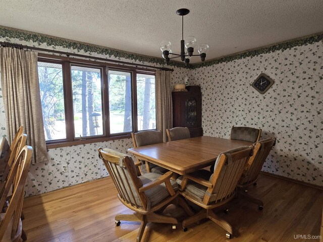 1604 Mildred Ave, Marquette, MI 49855 - dining space with a textured ceiling, a chandelier, wallpapered walls, and light wood-style floors