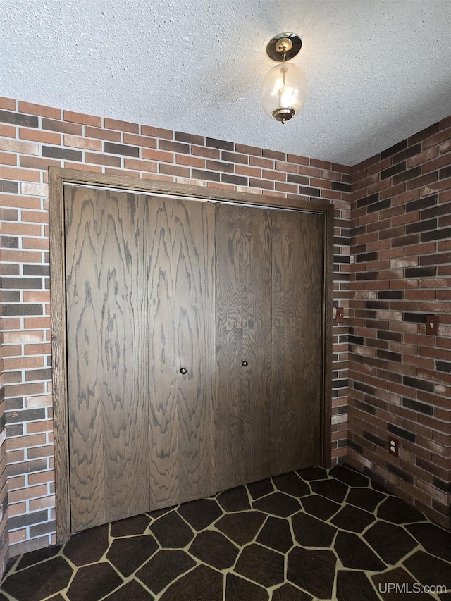 1604 Mildred Ave, Marquette, MI 49855 - interior space featuring a textured ceiling and brick wall