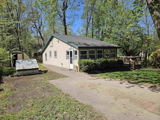 5440 Custer Dr, Harrison, MI 48625 - view of front facade with a deck, an outbuilding, and roof with shingles
