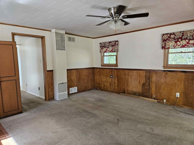 5440 Custer Dr, Harrison, MI 48625 - empty room featuring a heating unit, plenty of natural light, ceiling fan, wood walls, and a wainscoted wall