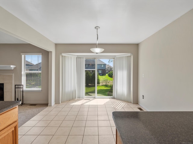 55374 Raspberry Dr, Macomb Twp, MI 48042 - unfurnished dining area with a fireplace, light tile patterned floors, and baseboards