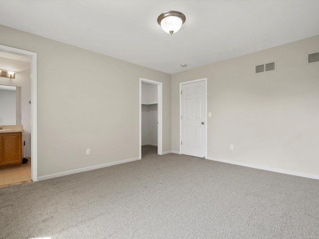 55374 Raspberry Dr, Macomb Twp, MI 48042 - unfurnished bedroom with light colored carpet, baseboards, a spacious closet, and ensuite bath