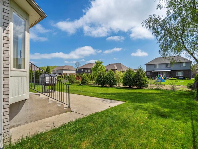 55374 Raspberry Dr, Macomb Twp, MI 48042 - view of grassy yard with a residential view and a patio