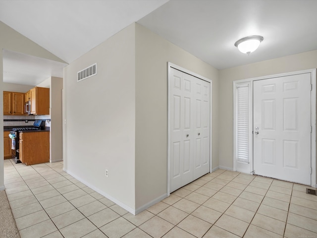 55374 Raspberry Dr, Macomb Twp, MI 48042 - foyer with light tile patterned flooring, vaulted ceiling, and baseboards