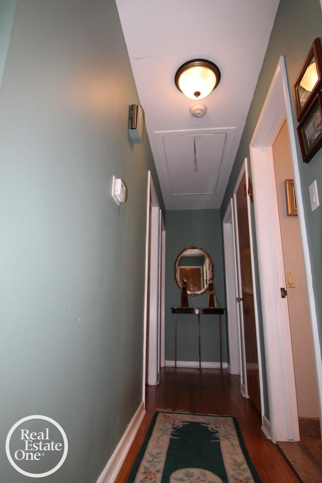 hallway featuring wood finished floors and baseboards
