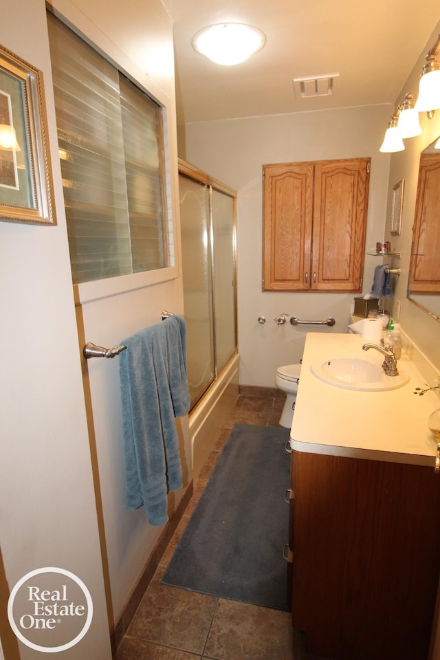 bathroom with tile patterned flooring, vanity, toilet, and enclosed tub / shower combo