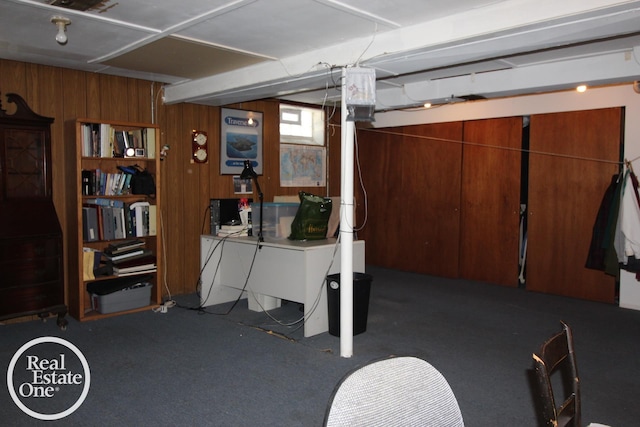 below grade area featuring carpet flooring and wood walls