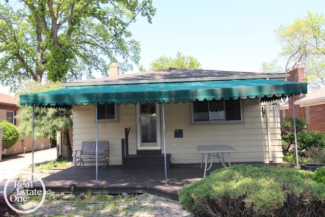 view of front of home with a wooden deck and a chimney