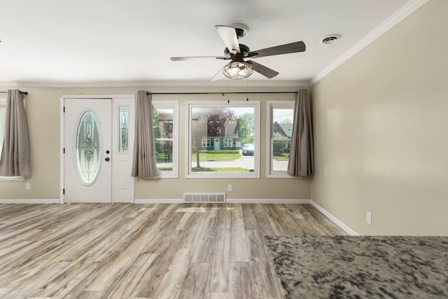 entryway with light wood-style flooring, ornamental molding, ceiling fan, and baseboards