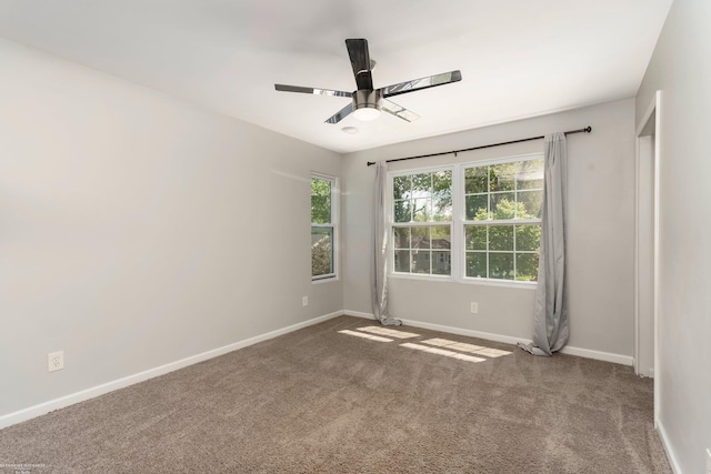carpeted empty room with baseboards and a ceiling fan