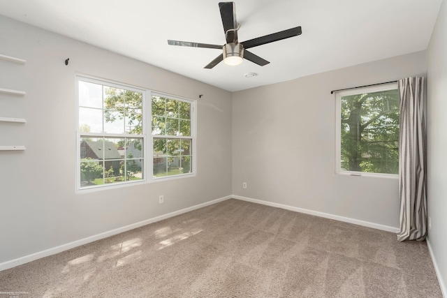 spare room with carpet floors, baseboards, and ceiling fan