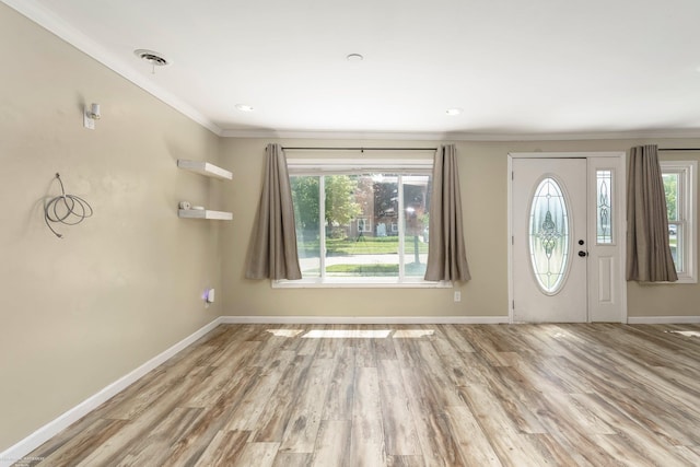 foyer with ornamental molding, wood finished floors, and baseboards