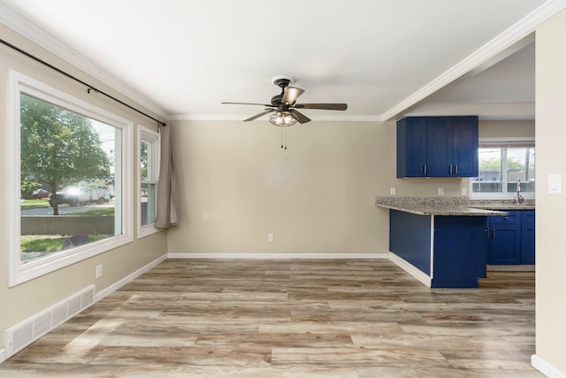 kitchen featuring blue cabinetry, light wood-style floors, ceiling fan, crown molding, and baseboards