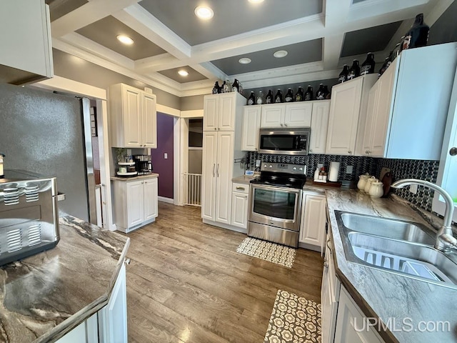 624 S 16th St, Escanaba, MI 49829 - kitchen featuring appliances with stainless steel finishes, a sink, coffered ceiling, tasteful backsplash, and white cabinets