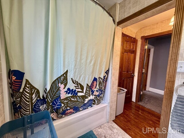 624 S 16th St, Escanaba, MI 49829 - full bath with shower / bath combination with curtain, wood finished floors, and tile walls