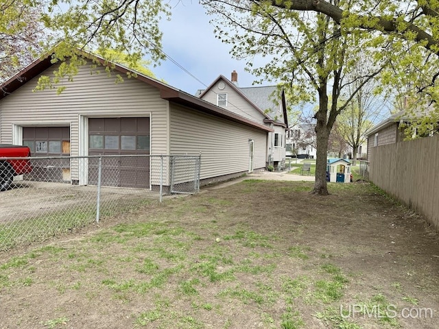 624 S 16th St, Escanaba, MI 49829 - view of home's exterior with fence, a garage, and a chimney
