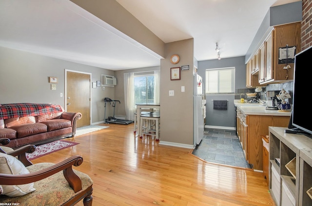 34485 Garfield Rd Apt # 1, Fraser, MI 48026 - living area with a wall mounted AC, light wood-type flooring, and baseboards