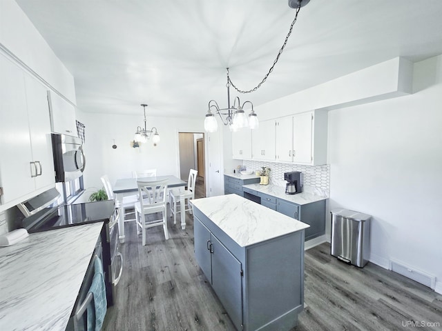 1400 W B St, Iron Mountain, MI 49801 - kitchen with a chandelier, dark wood-style floors, stainless steel appliances, and white cabinetry