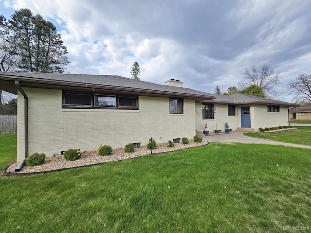 1400 W B St, Iron Mountain, MI 49801 - back of house with a chimney, brick siding, and a yard