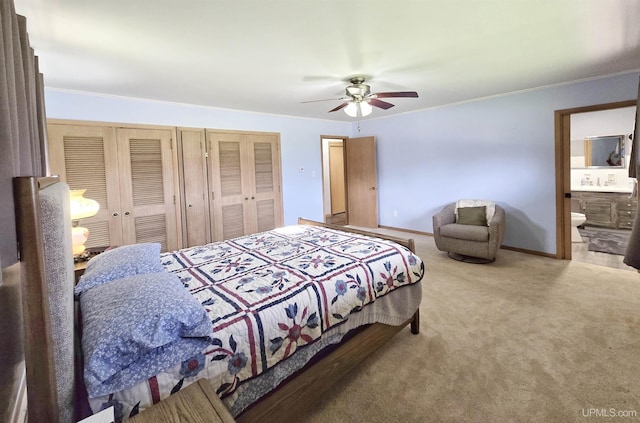 1400 W B St, Iron Mountain, MI 49801 - carpeted bedroom featuring ornamental molding, two closets, baseboards, ceiling fan, and connected bathroom