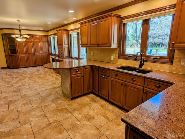 1002 Allouez Rd, Marquette, MI 49855 - kitchen with a sink, a peninsula, ornamental molding, brown cabinetry, and backsplash
