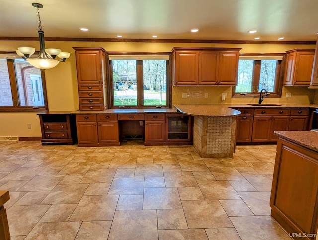 1002 Allouez Rd, Marquette, MI 49855 - kitchen featuring a sink, brown cabinetry, tasteful backsplash, pendant lighting, and ornamental molding