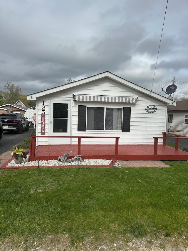 125 Wickham Ave, Houghton Lake, MI 48629 - view of front facade featuring a front lawn and a deck