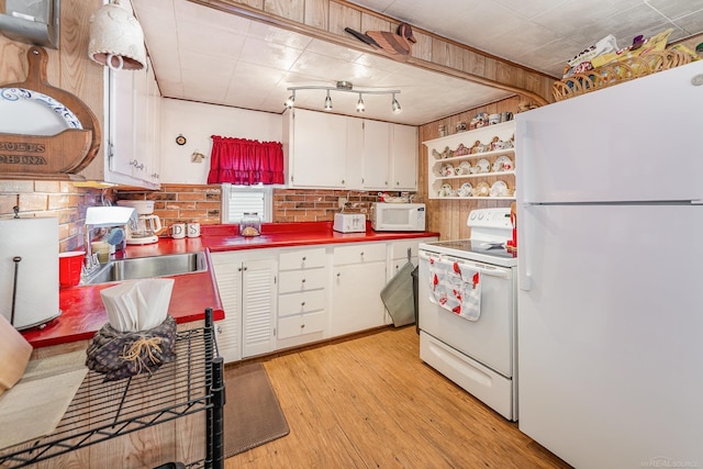 125 Wickham Ave, Houghton Lake, MI 48629 - kitchen with white appliances, light wood-style floors, white cabinets, and a sink