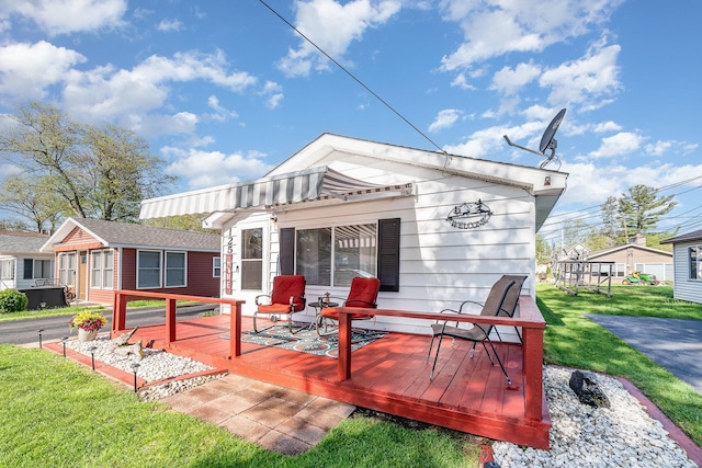 125 Wickham Ave, Houghton Lake, MI 48629 - back of property featuring a wooden deck and a lawn