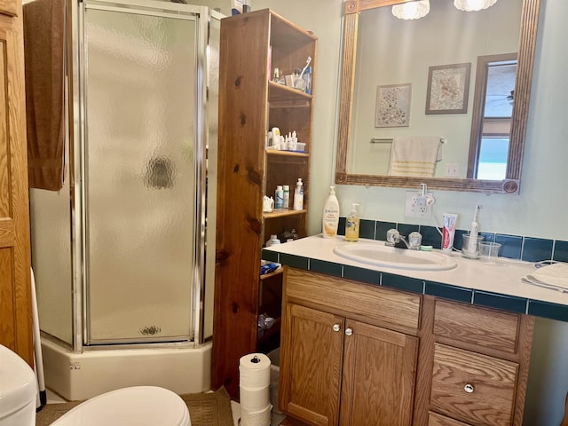 bathroom featuring a stall shower, toilet, and vanity
