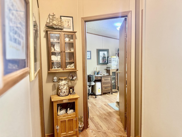 hallway with light wood-style floors and an office area