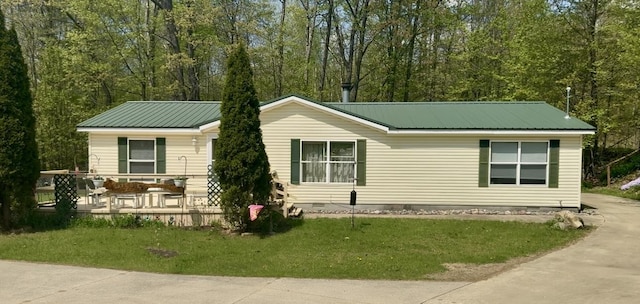 view of front facade featuring a front lawn, metal roof, and crawl space