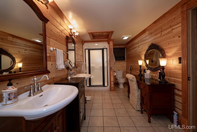 382 S Shore Dr, Crystal Falls, MI 49920 - full bathroom with wooden walls, a stall shower, tile patterned flooring, toilet, and two vanities