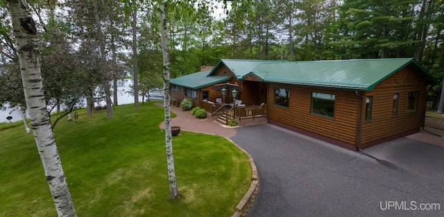 382 S Shore Dr, Crystal Falls, MI 49920 - view of front facade with faux log siding, a front lawn, driveway, and metal roof