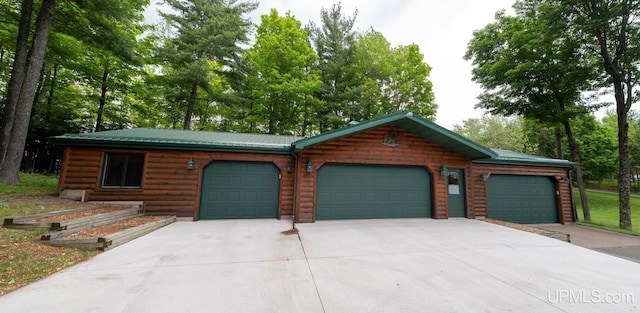 382 S Shore Dr, Crystal Falls, MI 49920 - cabin featuring driveway, a garage, metal roof, and faux log siding
