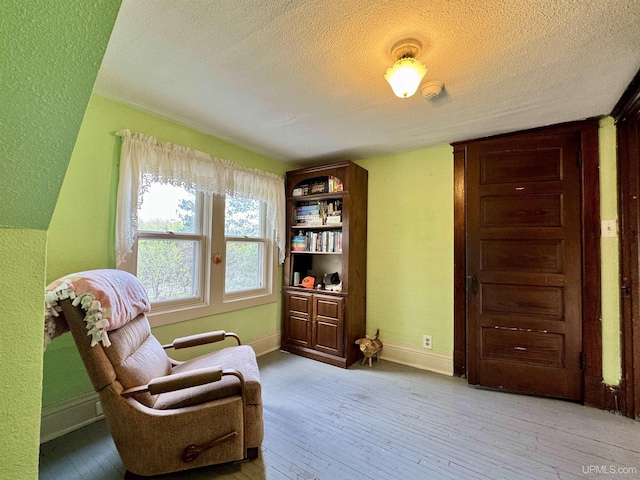 18020 Lake Rd, Pelkie, MI 49958 - sitting room featuring a textured ceiling, light wood-type flooring, and baseboards