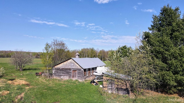18020 Lake Rd, Pelkie, MI 49958 - view of home's exterior with a barn, a yard, an outdoor structure, a chimney, and metal roof